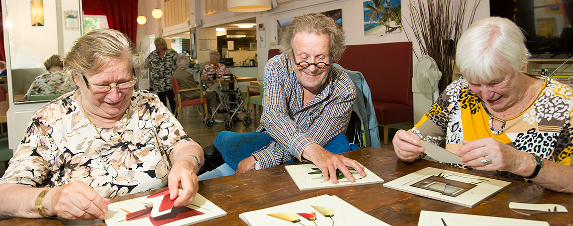Auf dem Foto sehen Sie drei Senioren mit Alzheimer/Demenz, die mit speziellen Puzzles für Menschen mit fortgeschrittener Demenz spielen. Diese speziellen Puzzles wurden bei SpielePlus: Spiele für Senioren gekauft. Deutlich erkennbar ist, dass Puzzeln auch für Menschen mit Demenz eine sehr unterhaltsame Aktivität ist.